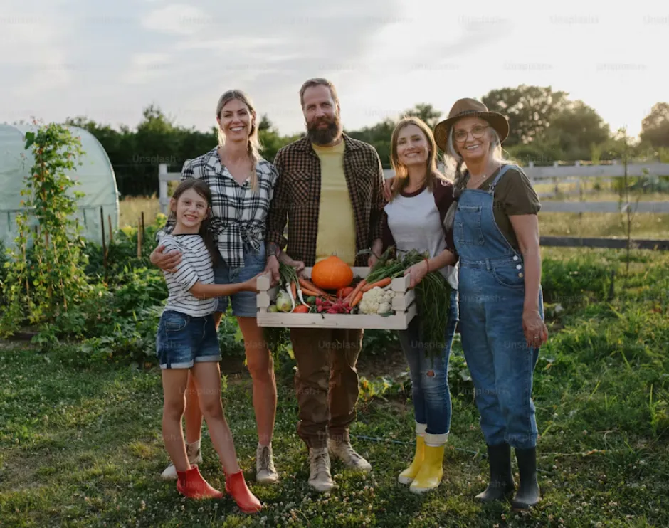 Famiglia nell'orto con una cassetta di verdure appena raccolte