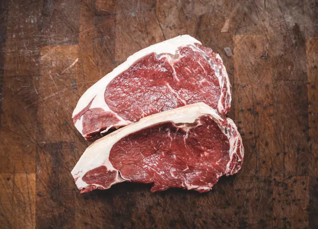 Tagli di carne fresca su un tagliere di legno